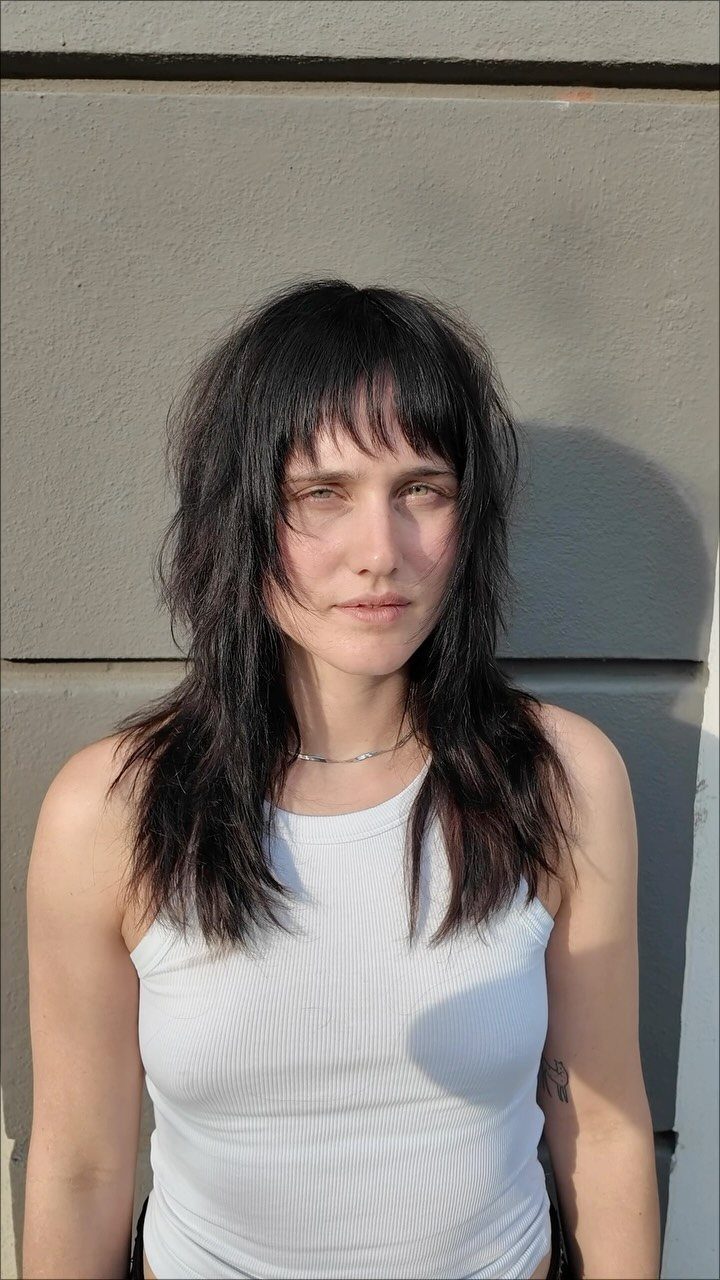 Woman with long dark hair and a short, uneven textured fringe