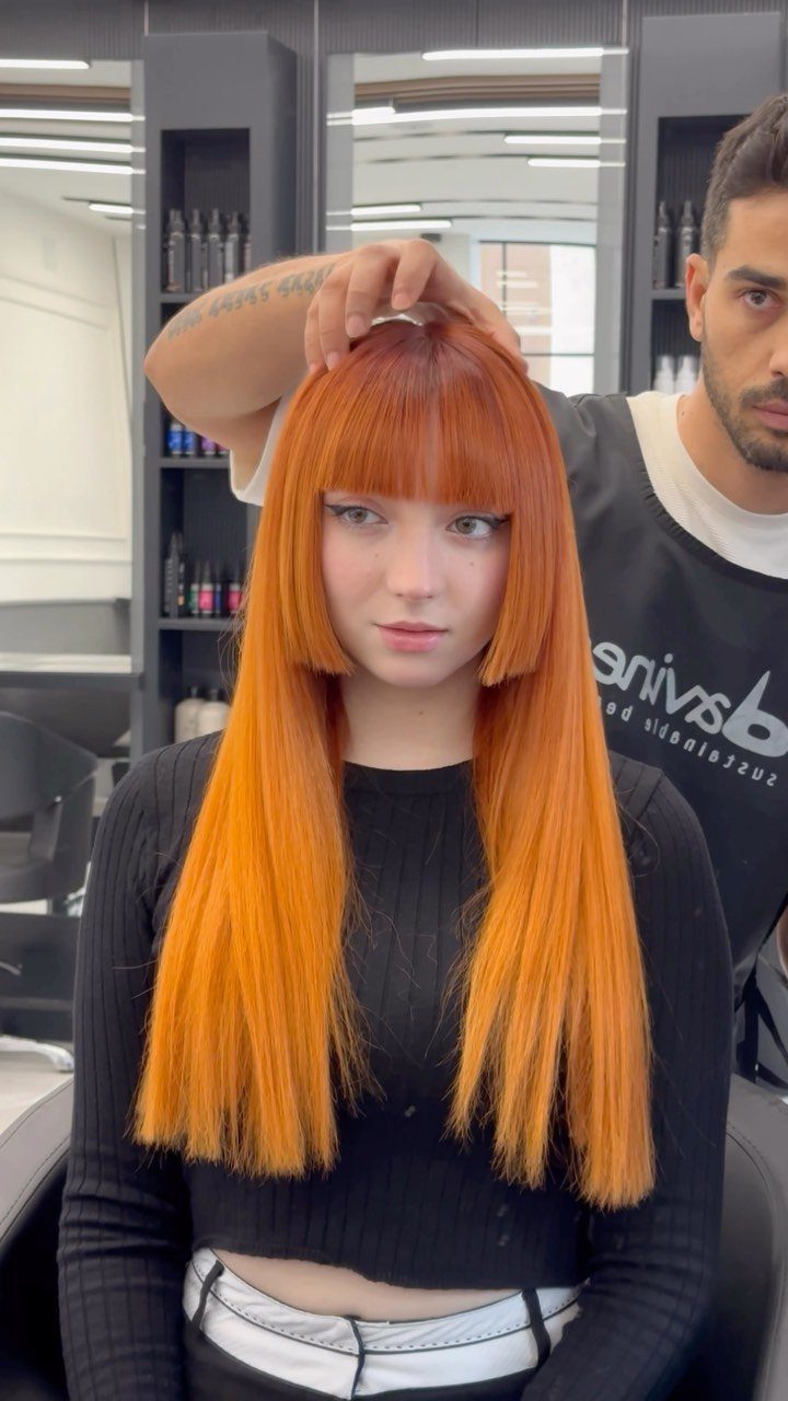 Woman with vivid orange hime haircut, microbangs, disconnected side sections, and long straight lengths