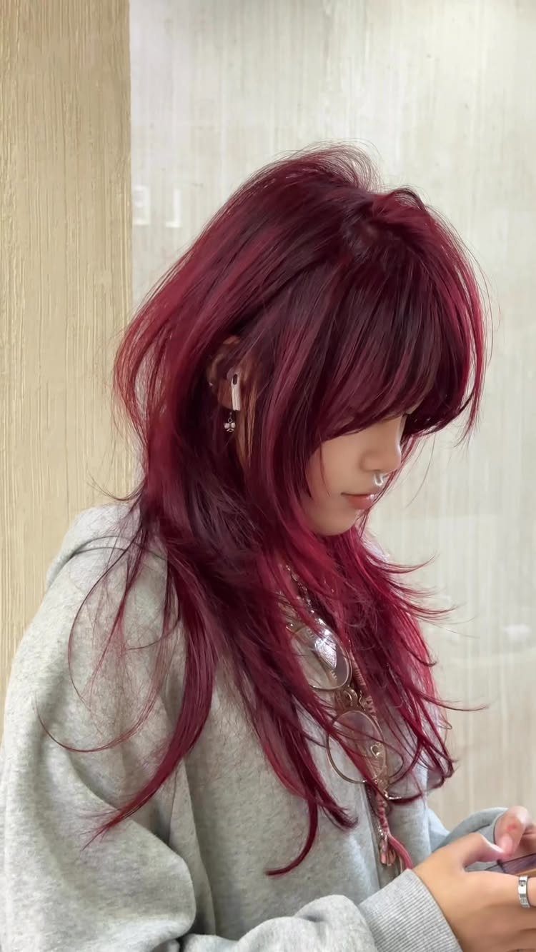Burgundy layered haircut with long bangs and curled face-framing lengths