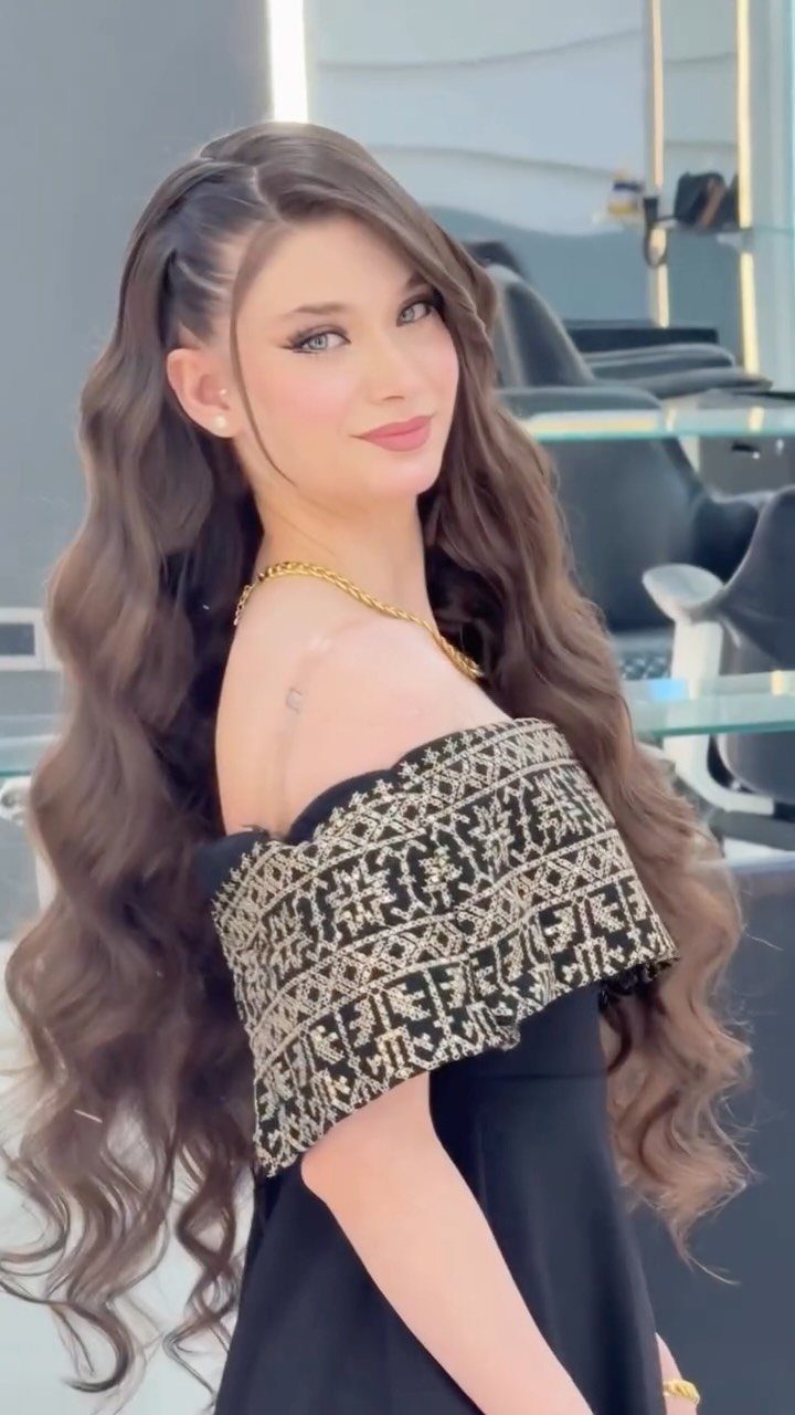 Woman posing with long, loose, glossy brown mermaid waves