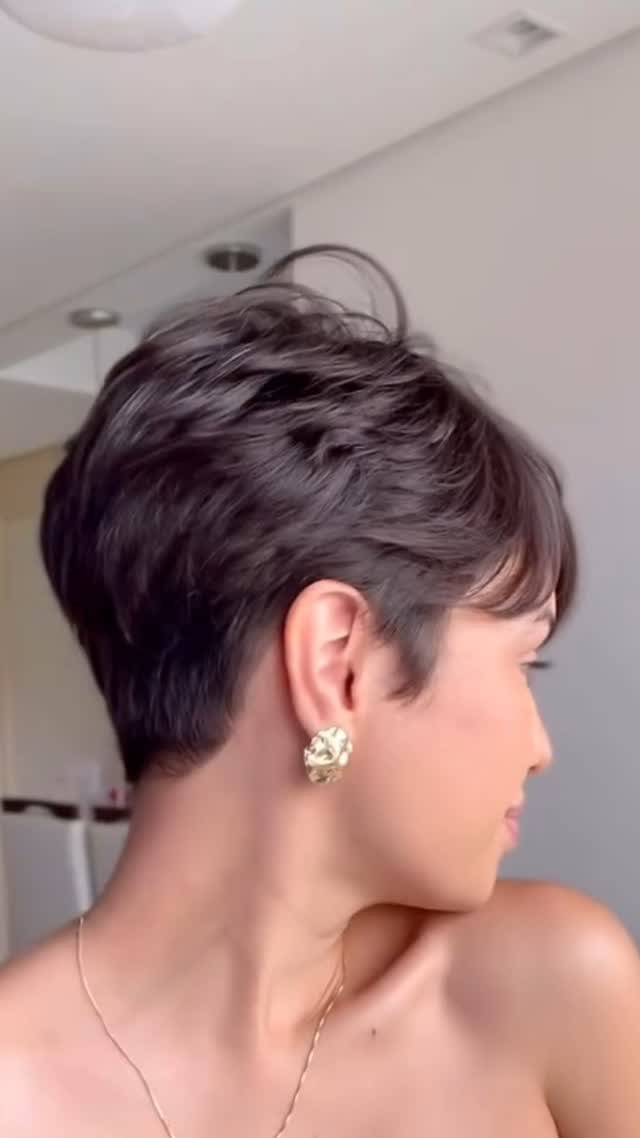Short dark pixie cut shown in side profile with a gold earring
