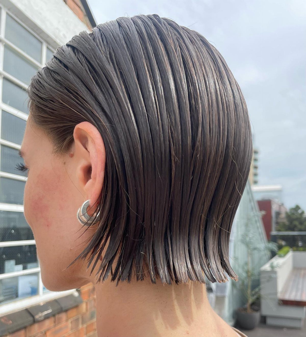 Slicked-back dark bob with glossy comb lines and blunt ends