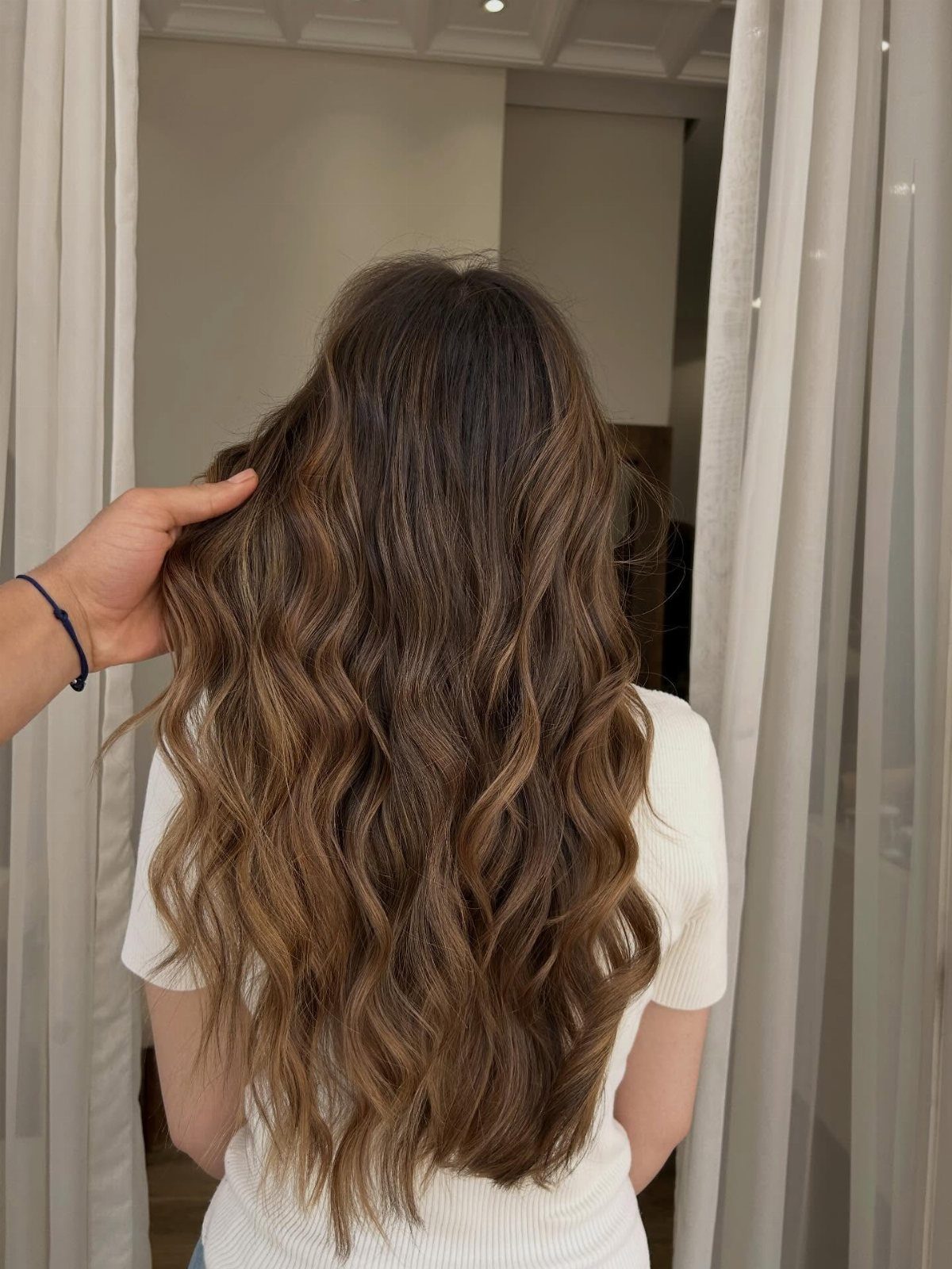 Long brown hair styled in soft loose waves viewed from behind