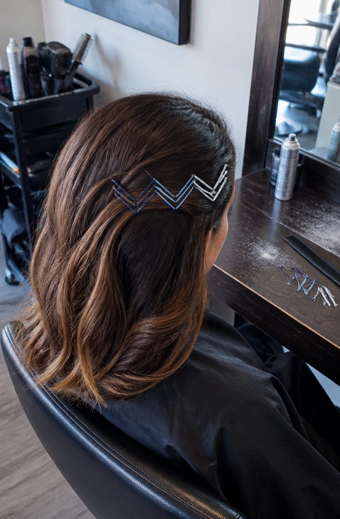 Navy light blue and white pins forming V shapes over bangs