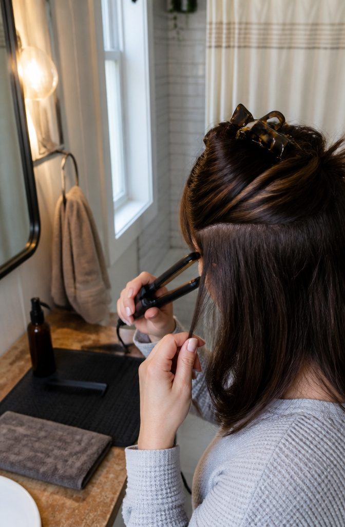 Mini flat iron directing short bangs toward one temple