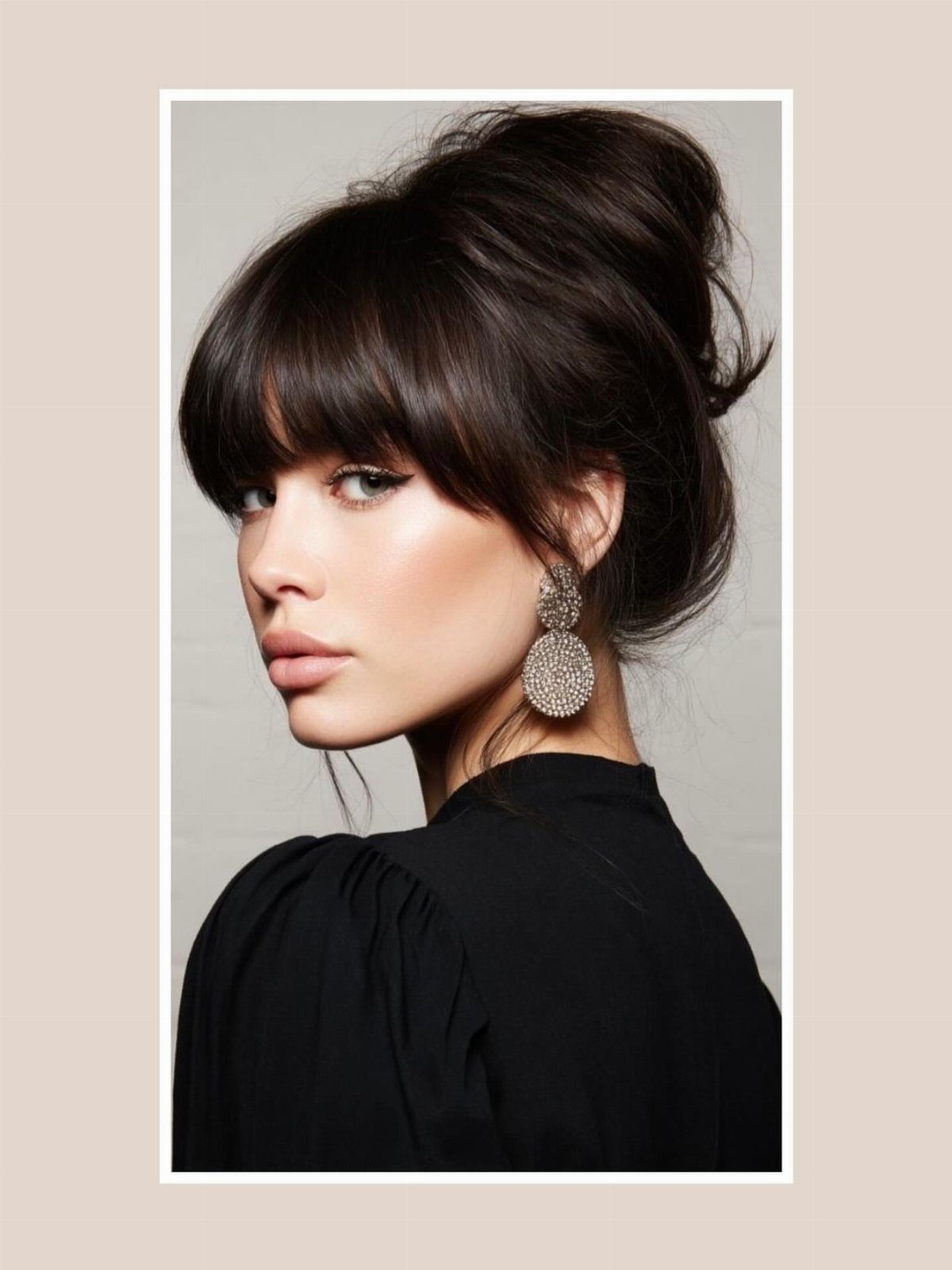 Woman with dark updo and soft bangs grazing her eyebrows