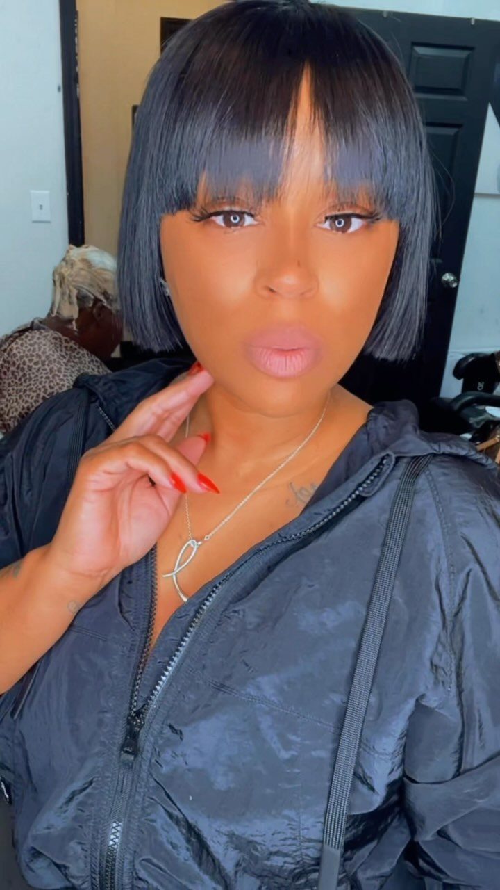 Woman wearing a sleek blunt bob with straight-across bangs