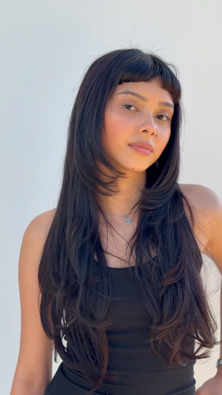 Woman with long dark hair and short blunt micro bangs