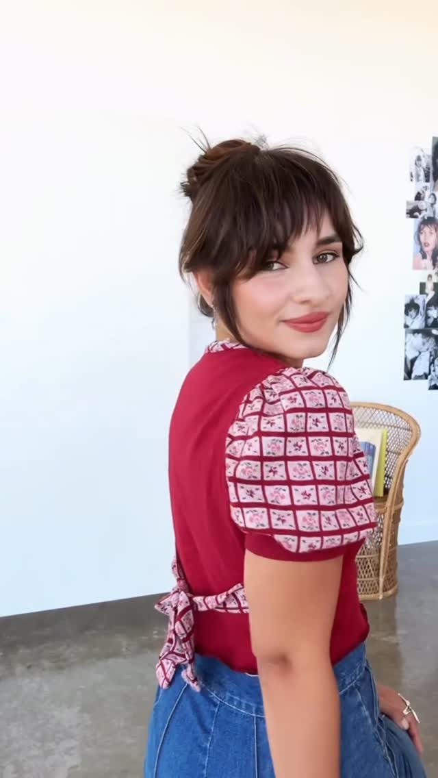 Woman showing medium-length tousled hair with wispy bangs indoors