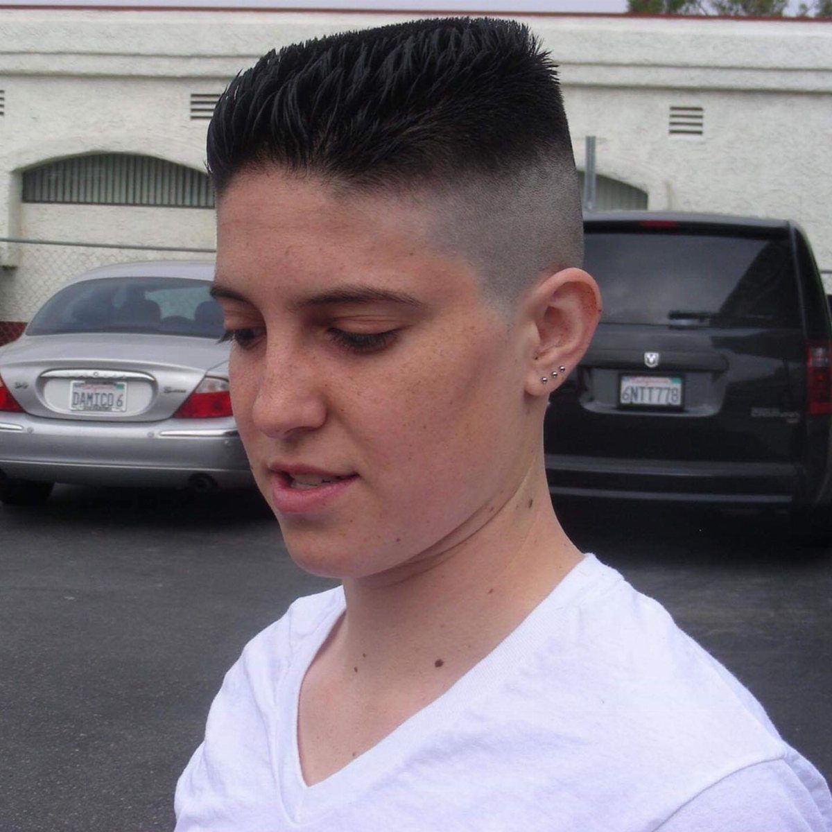 Short dark high-and-tight haircut with faded sides and upright top