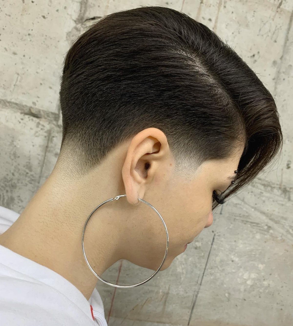 Dark swept hairstyle with a gradual taper at the sides and neckline