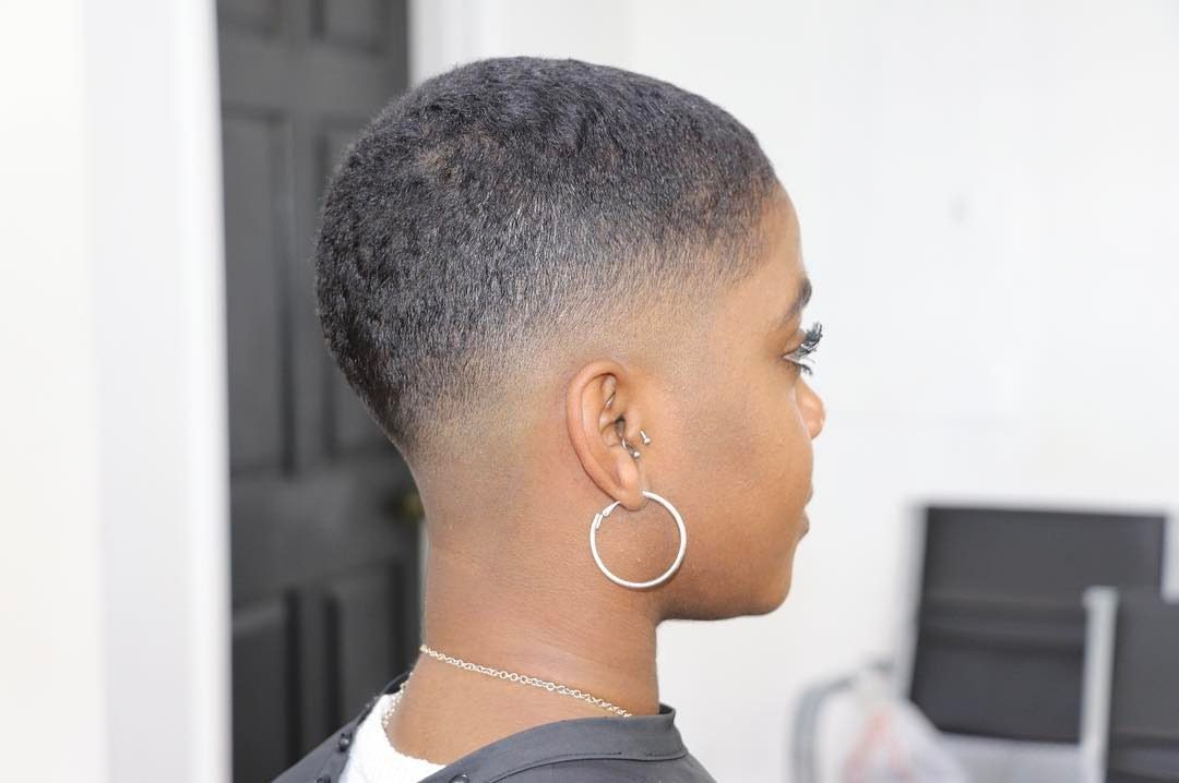 Person with a close-cropped haircut and tapered sides shown in profile
