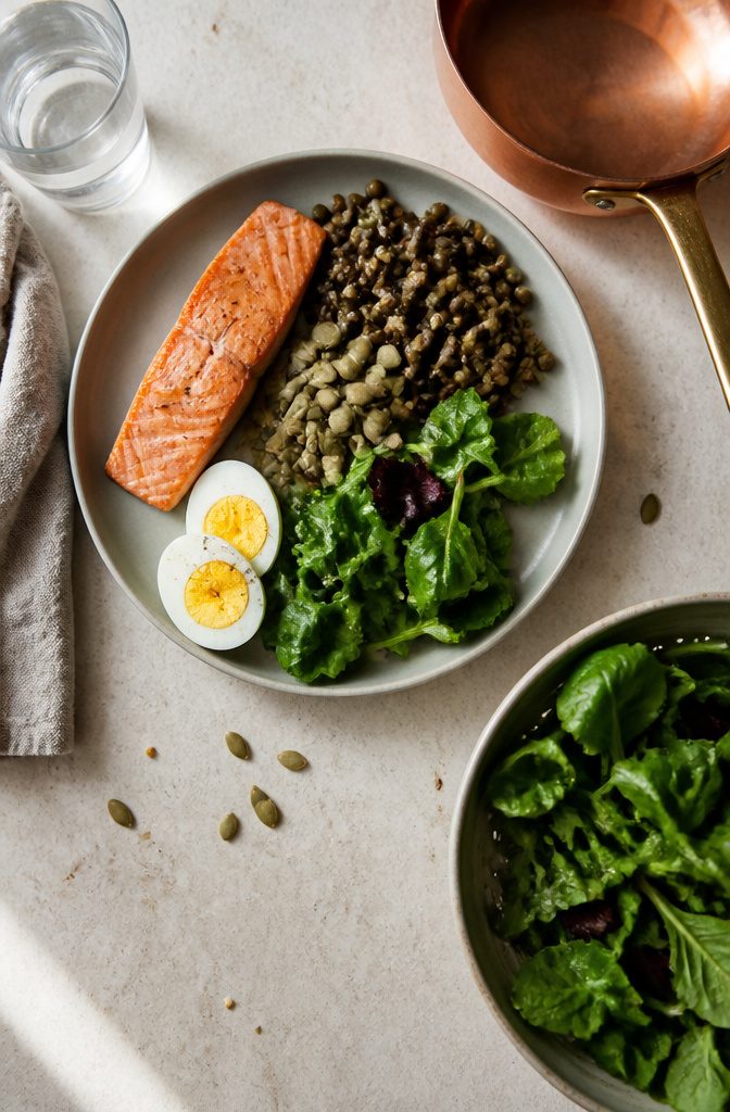 Eggs beans salmon lentils and leafy greens on a plate