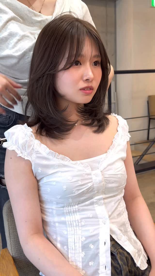 Woman showing shoulder-length layered lob with face-framing waves and textured ends