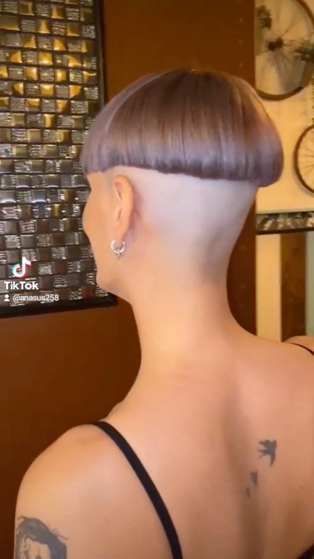 Short rounded brown haircut above closely shaved sides and nape