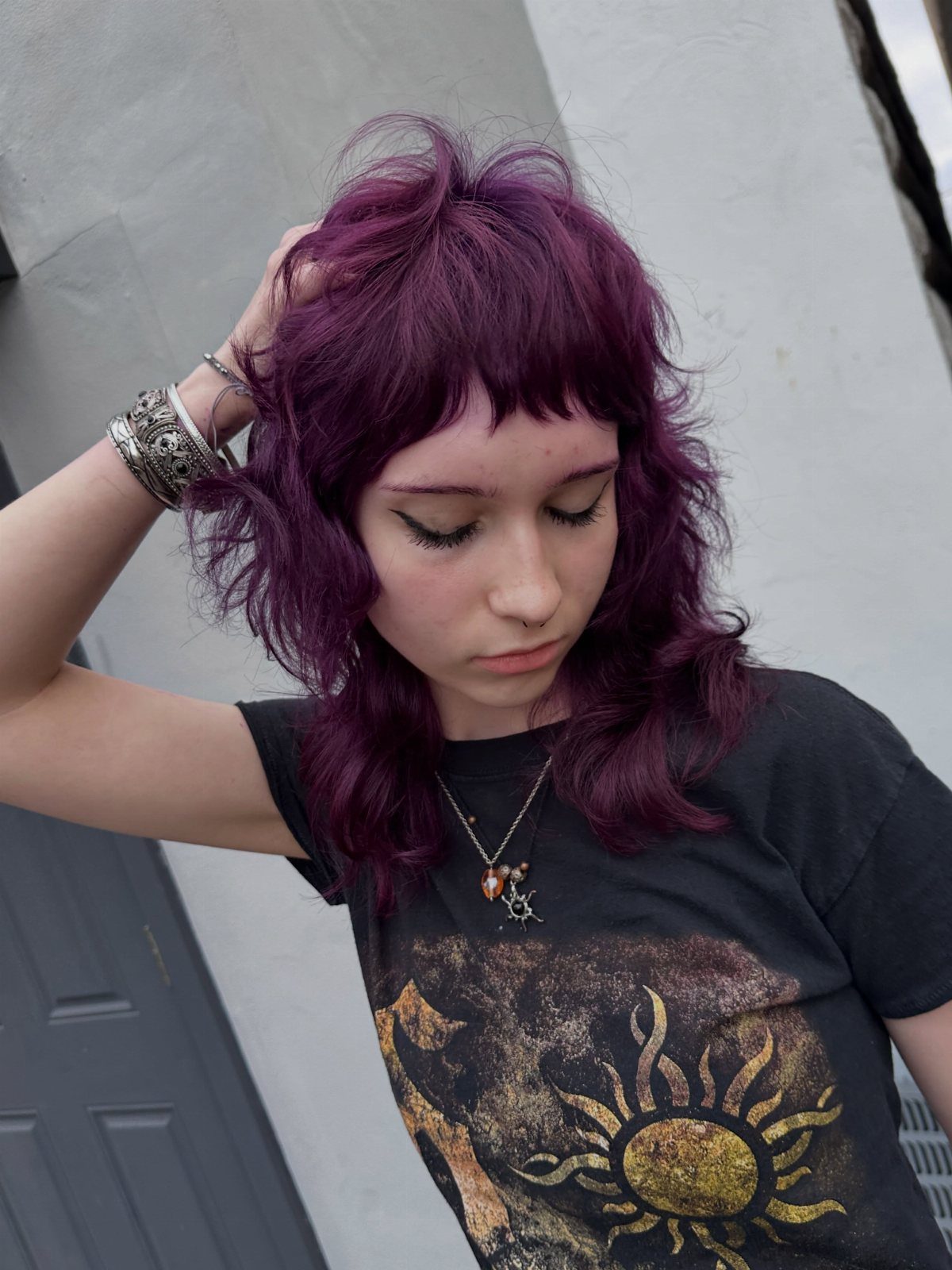 Person showing a tousled purple layered short haircut with bangs