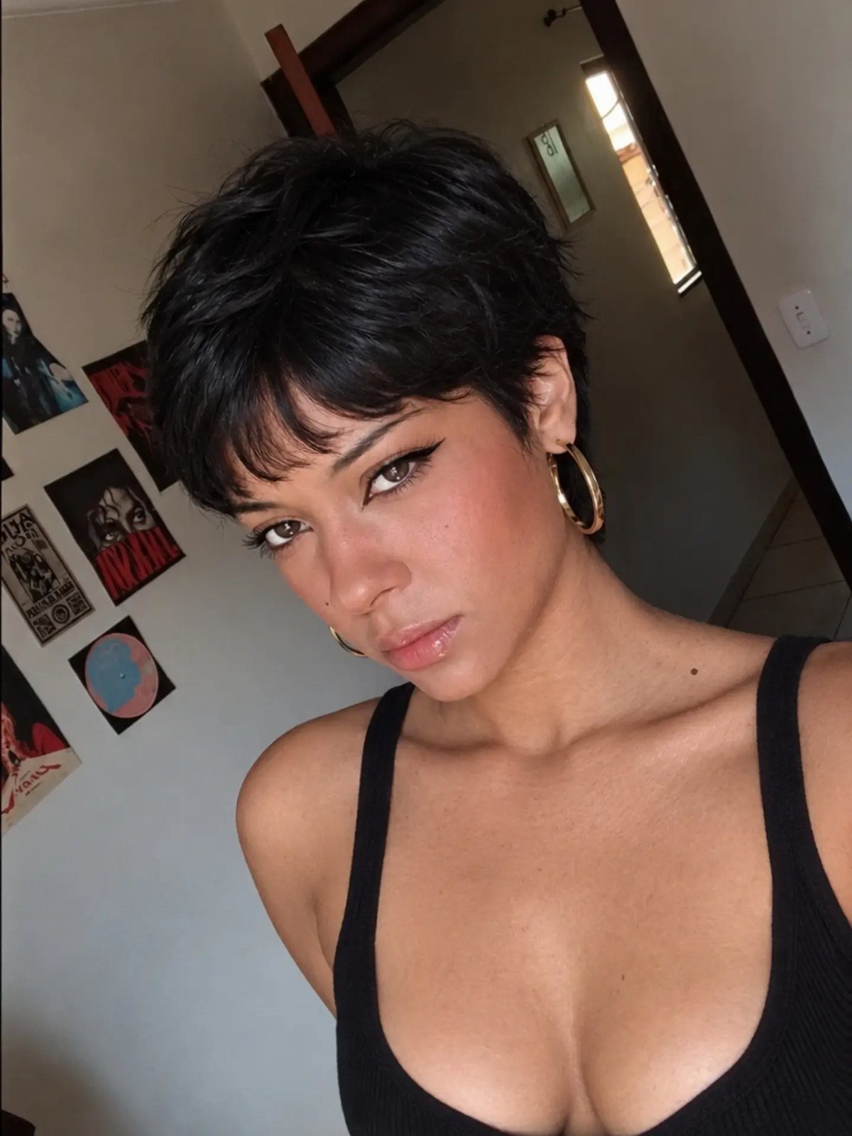 Person with a choppy dark pixie cut and side-swept layered fringe