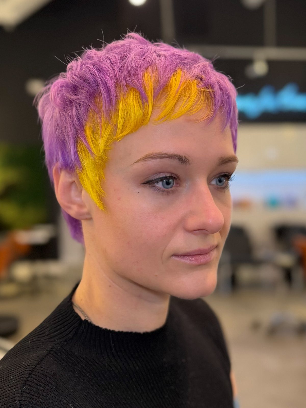 Short pixie haircut with purple layers and bright yellow face-framing highlights