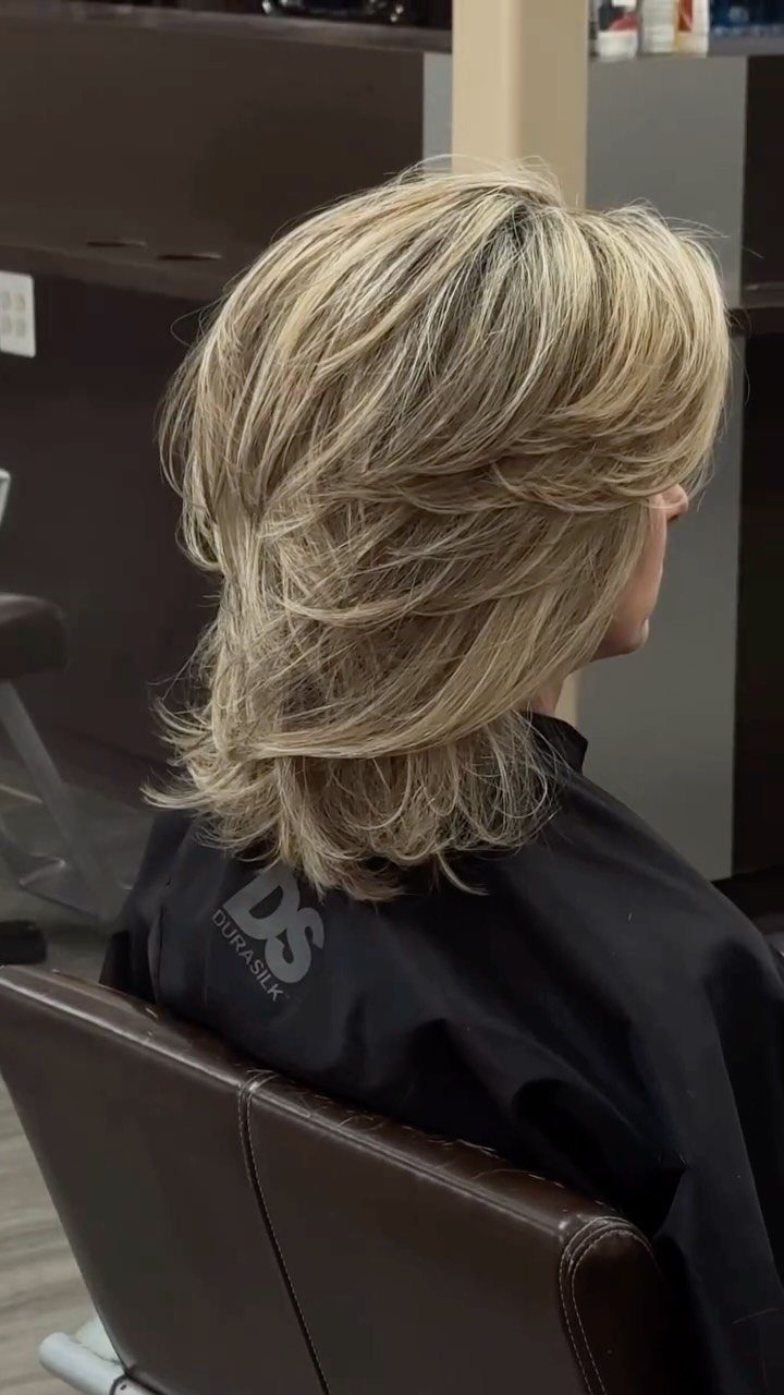 Voluminous blonde 90s layers styled in a feathered salon haircut