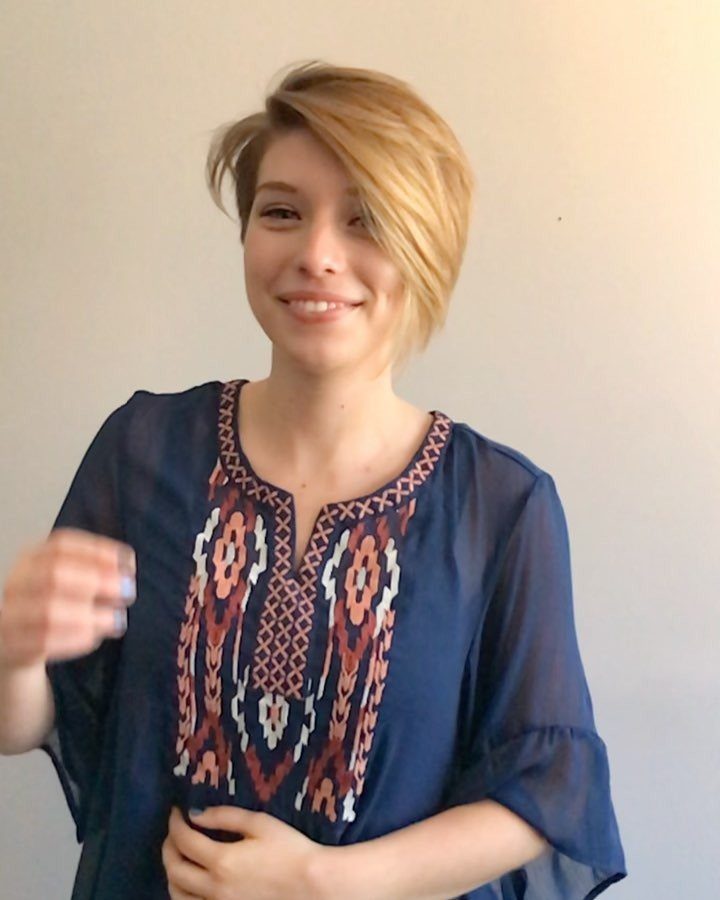 Woman with a short blonde layered haircut swept across one side