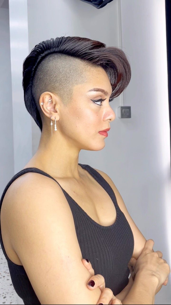 Woman showing layered pompadour hairstyle with shaved side in profile