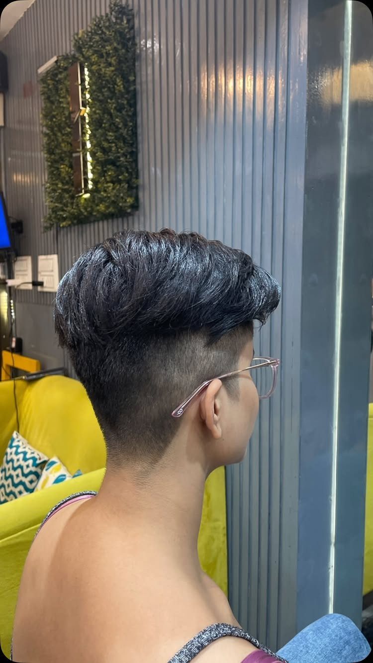 Person showing short layered textured hairstyle with tapered sides in side profile
