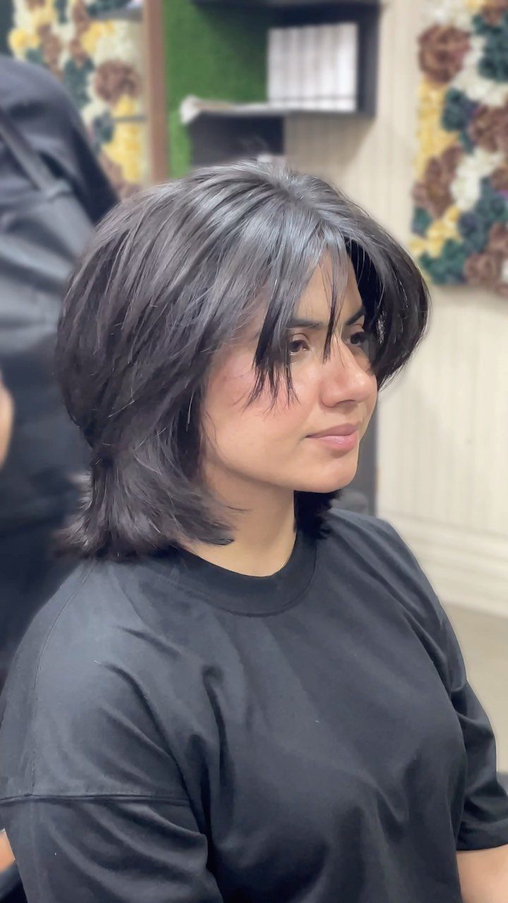 Woman showing a choppy, uneven layered bob with long face-framing pieces