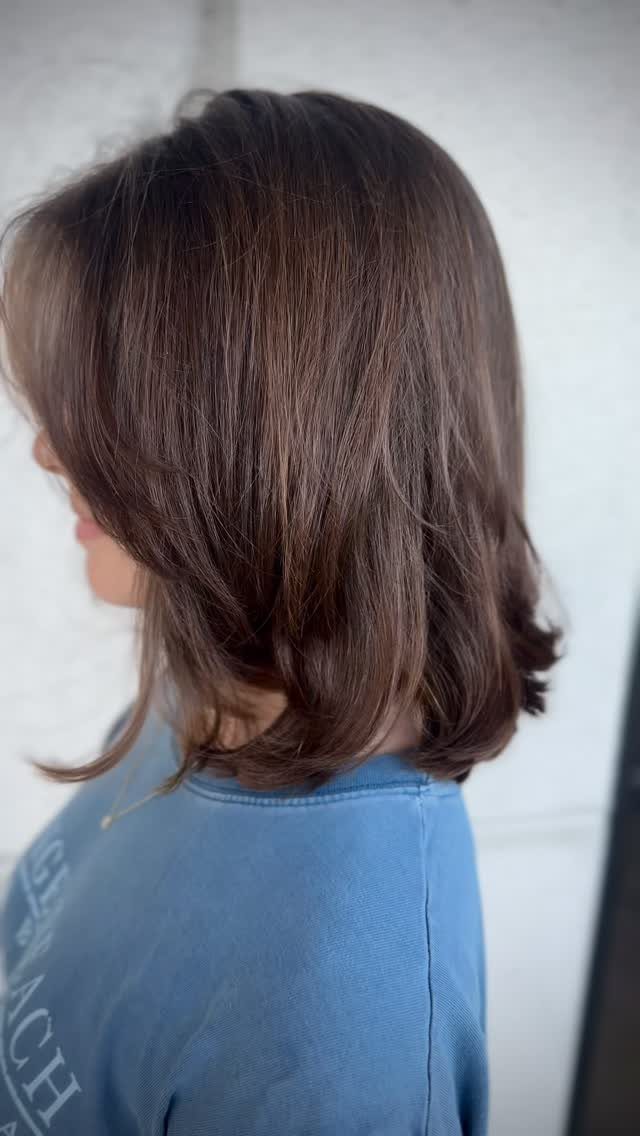 Layered lob with dark brown, shoulder-length hair and softly flipped ends
