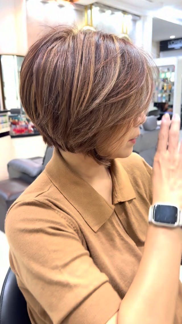 Short layered brown bob with blonde highlights and lifted crown layers