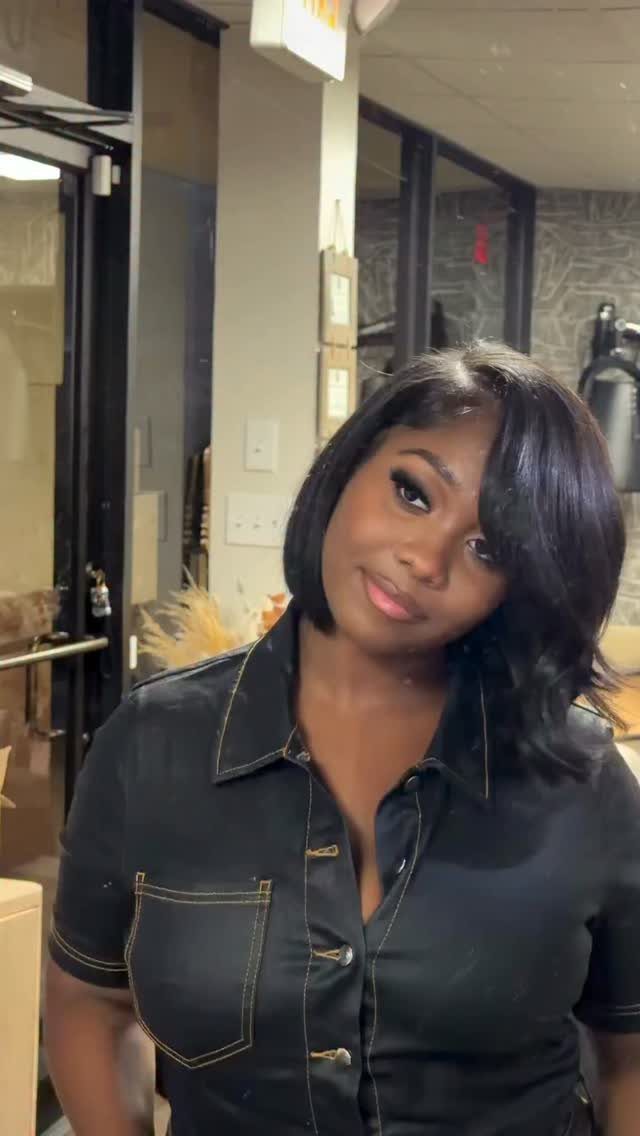 Woman showing a glossy, deeply side-parted layered bob with sweeping fringe