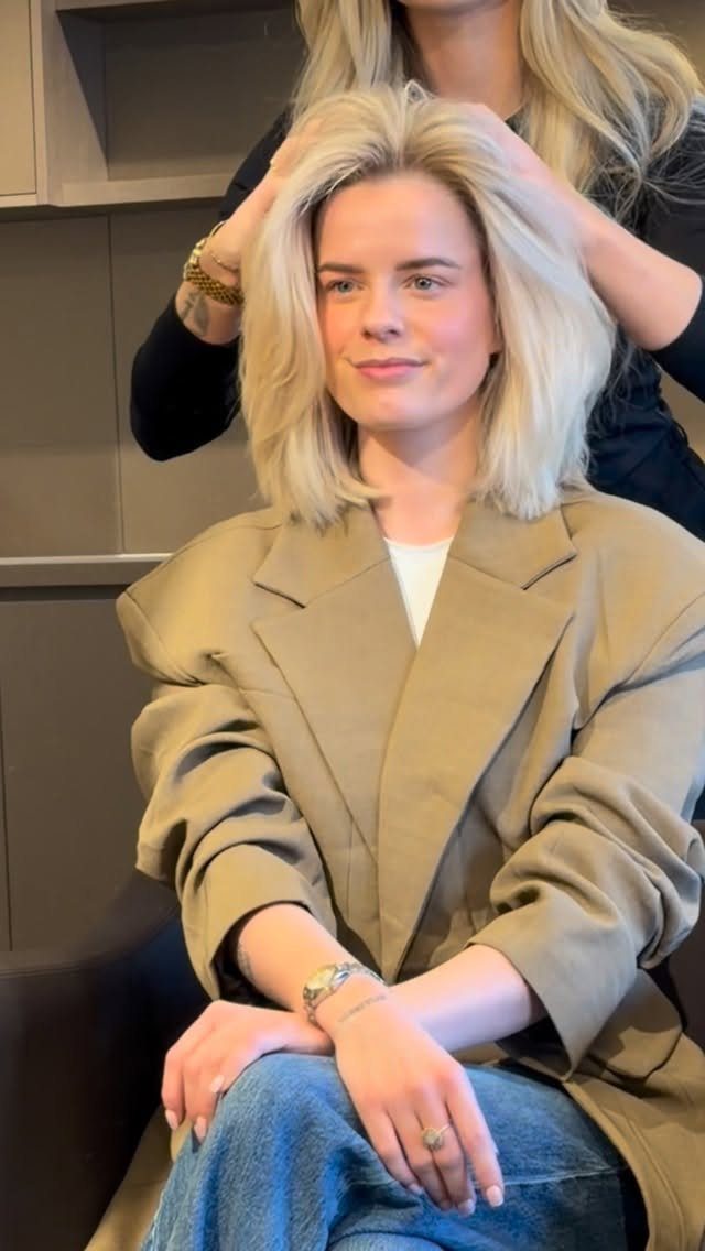 Straight blonde long bob with a center part styled by a salon professional