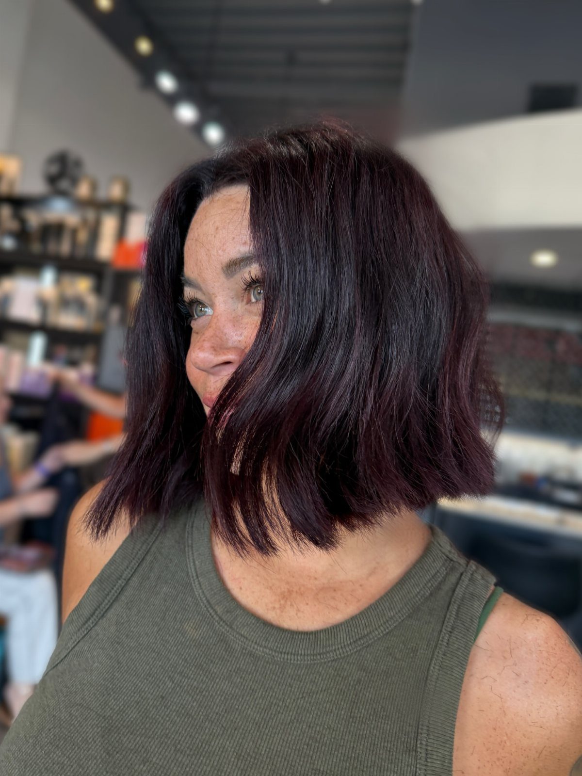 Woman with a dark chin-length bob sitting in a hair salon