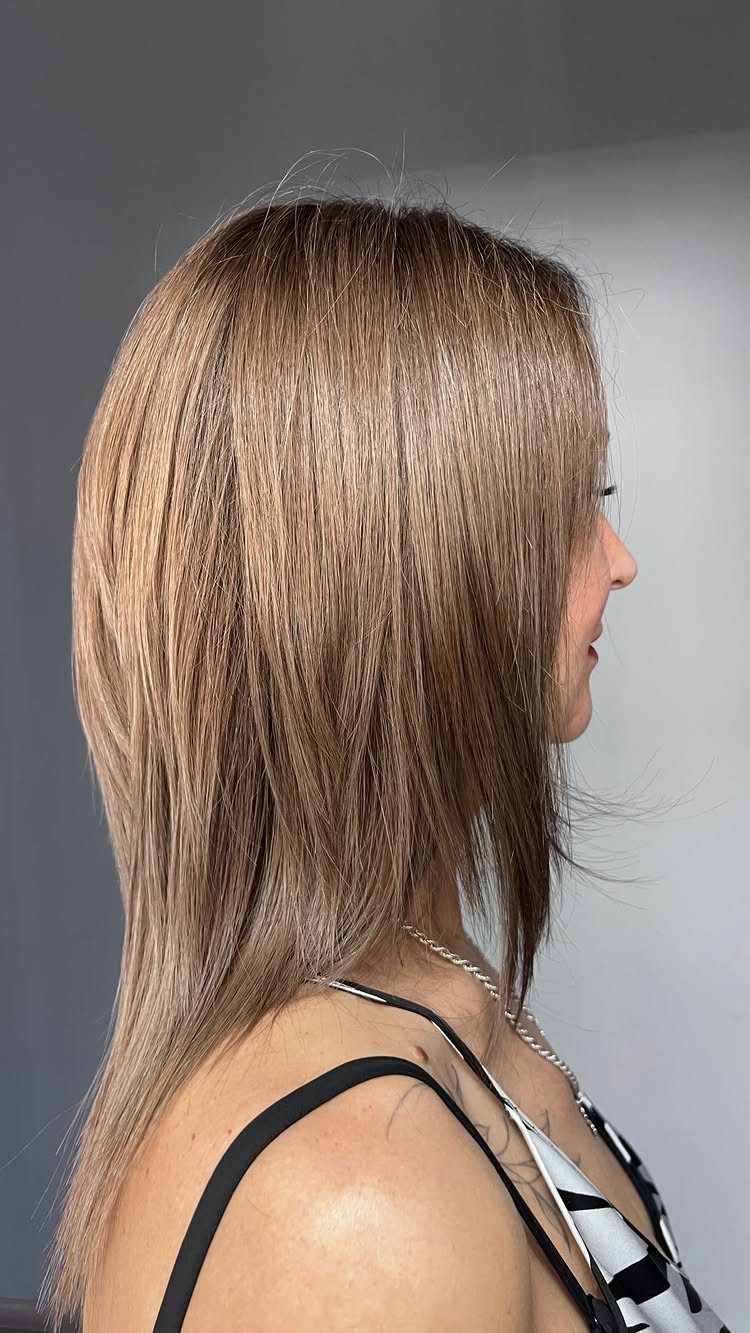Woman showing a highlighted layered bob with long face-framing front pieces