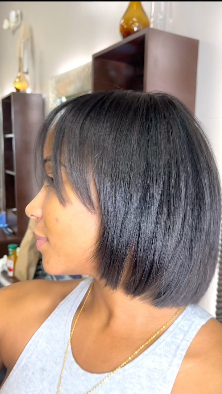 Smooth black layered bob with side-swept bangs shown in profile