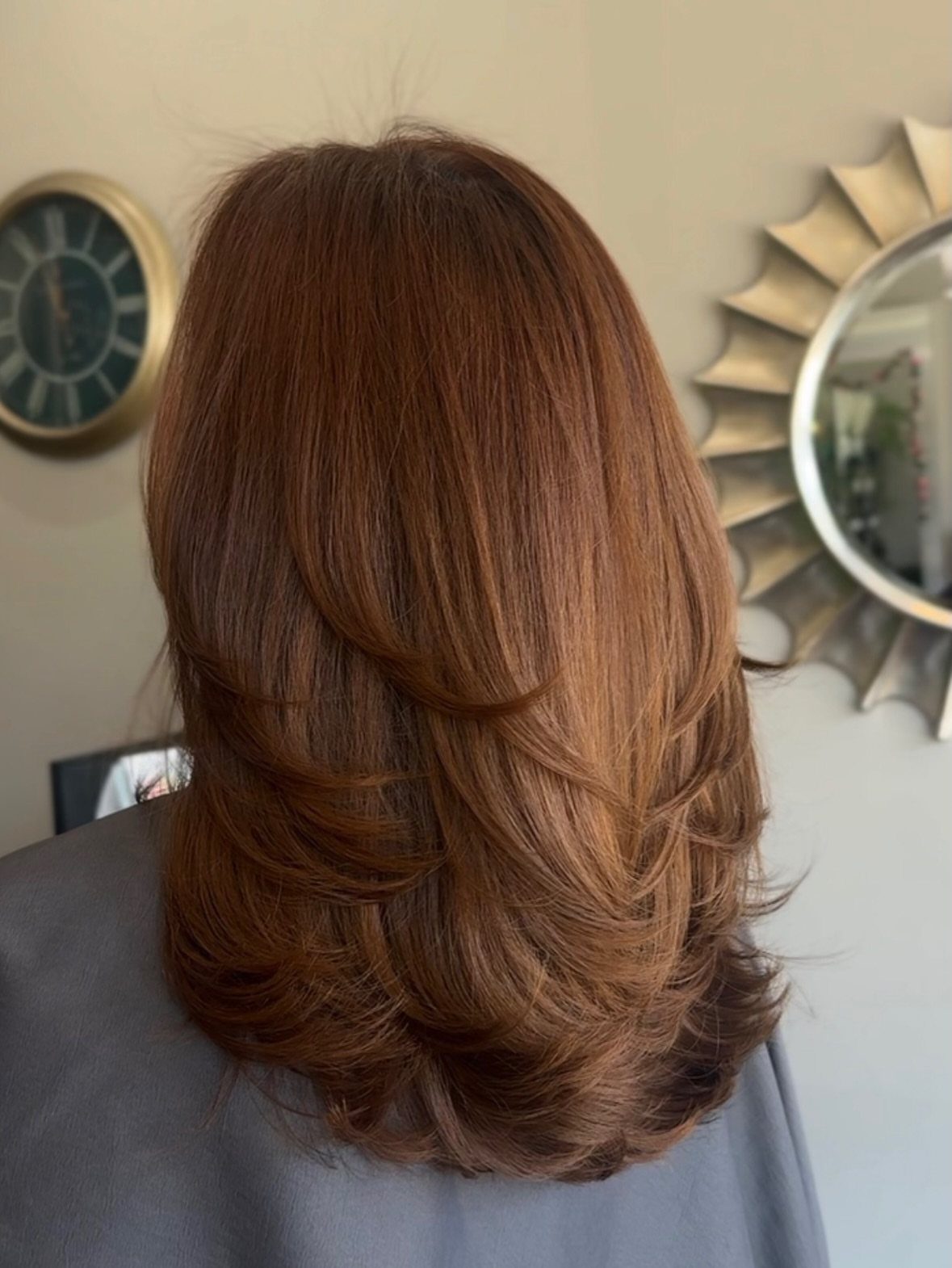 Shoulder-length chestnut layered hair with softly curled, feathered ends