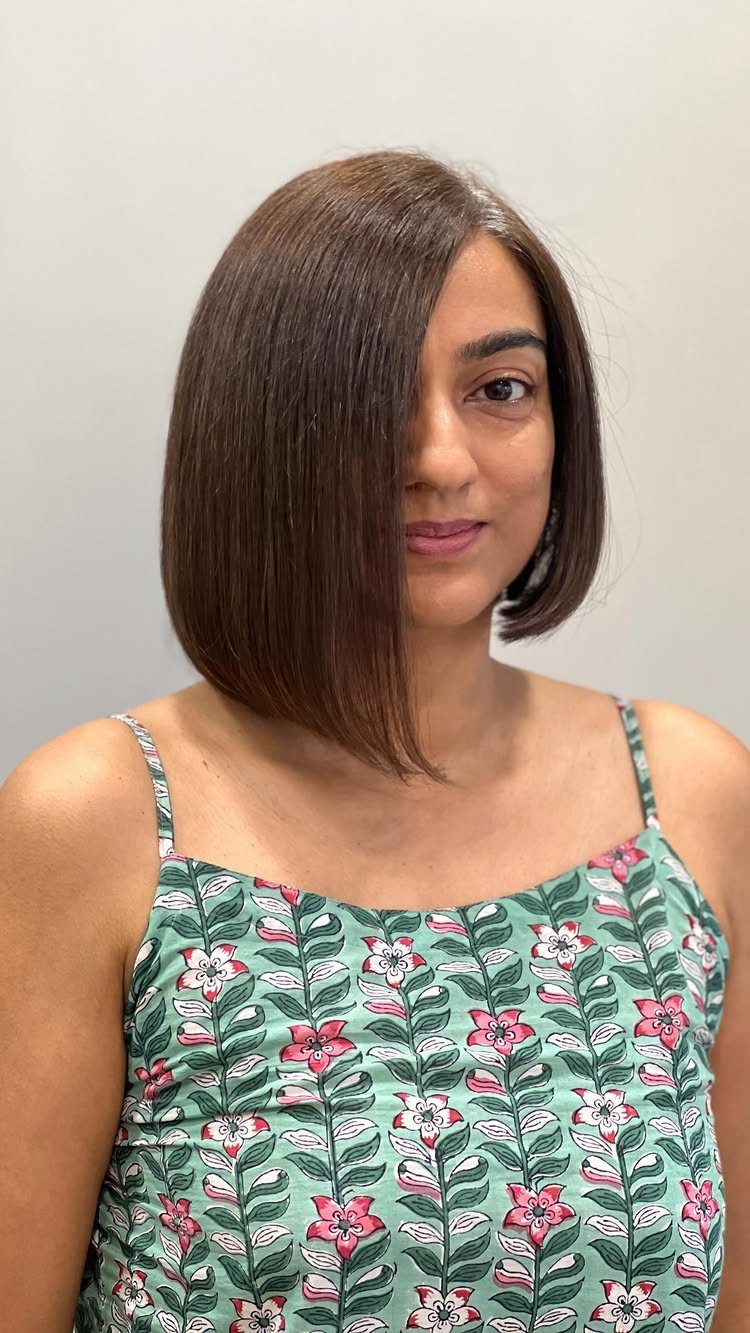 Woman showing a straight asymmetrical brown bob with one longer side