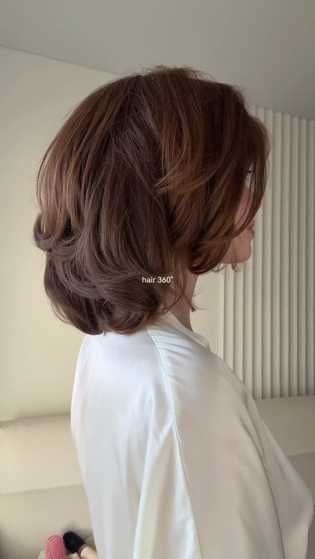 Layered dark brown bob with lifted volume and curled-under ends