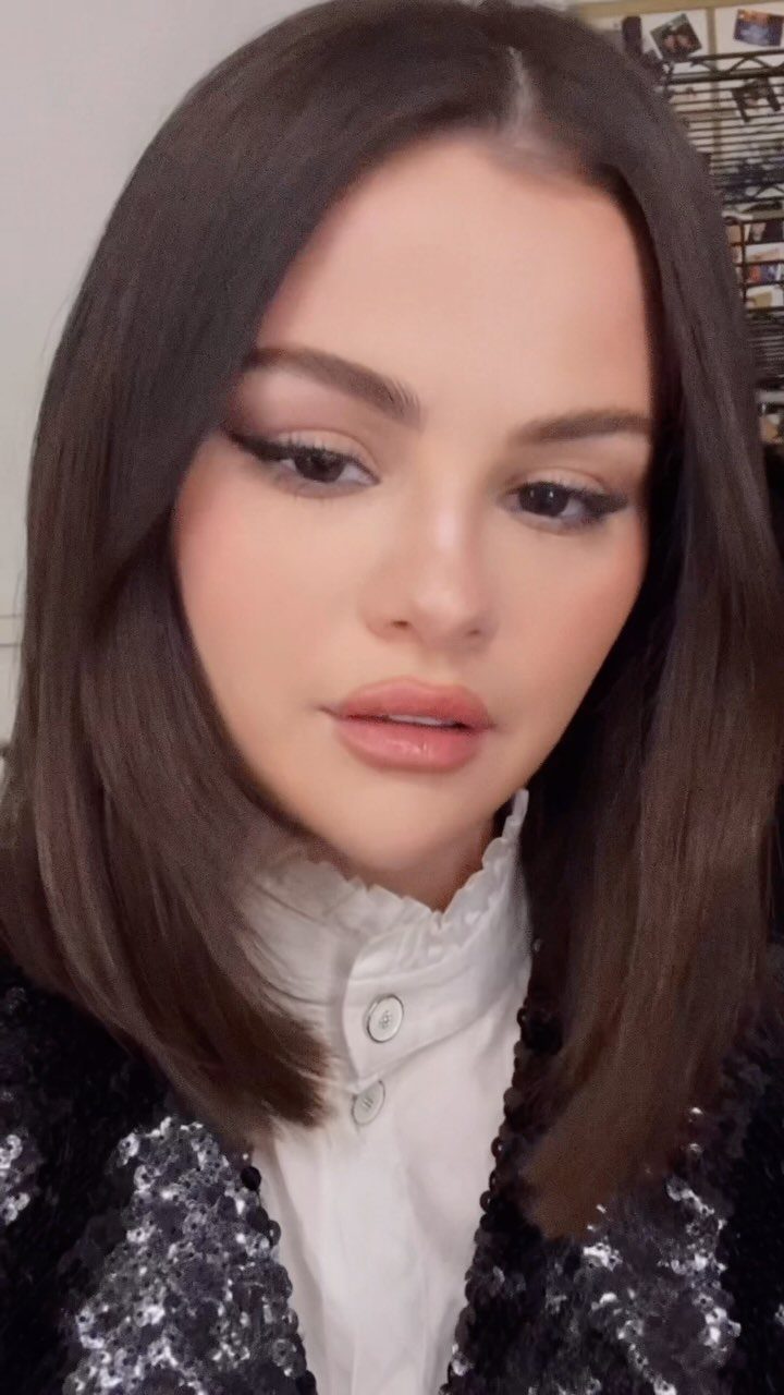 Woman showing a sleek, blunt shoulder-length dark brown lob haircut