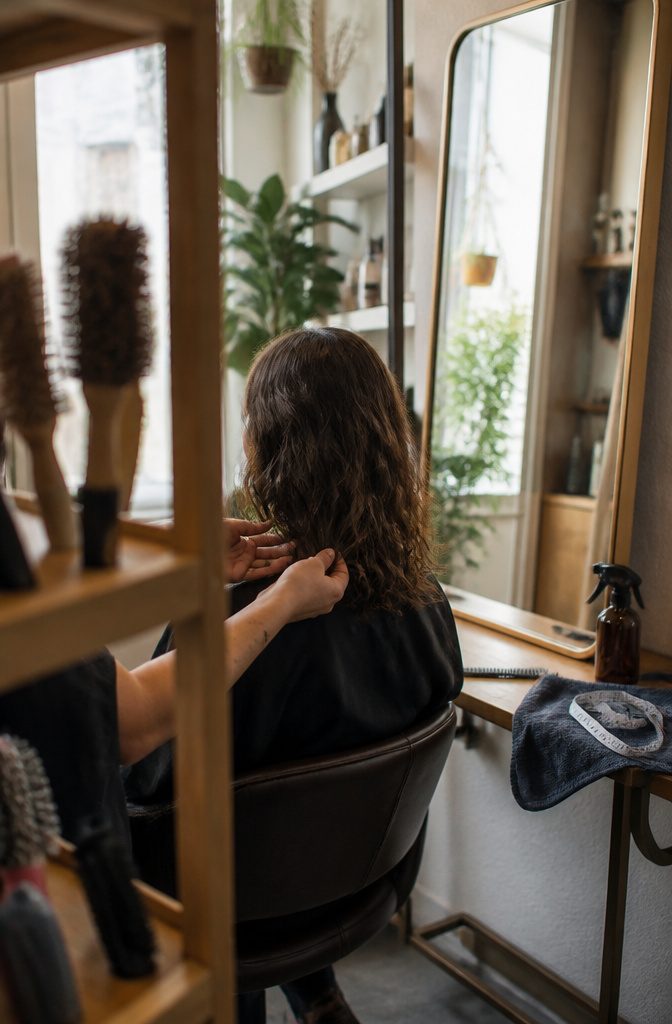 Wavy layered hair stretched down a woman’s back with shorter layers