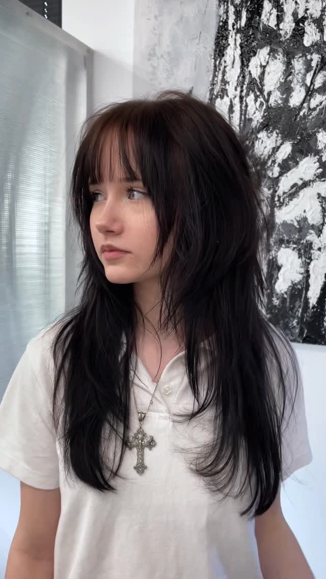 Young woman with long dark layered hair and a fine blended fringe