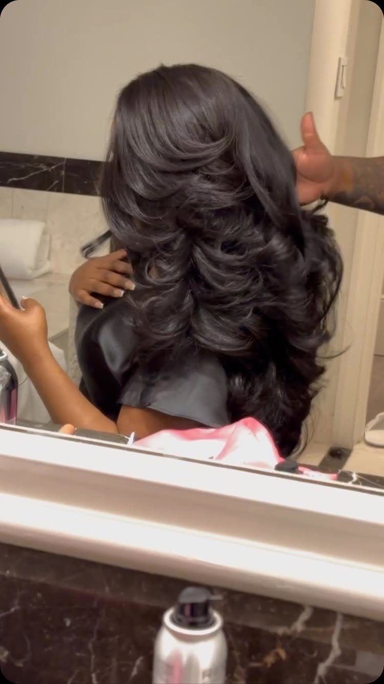 Long dark hair with voluminous layers and curled ends shown from behind