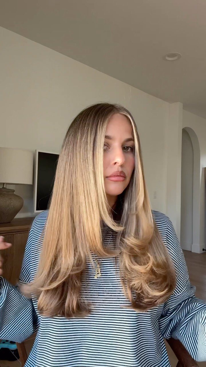 Woman with long highlighted layers styled to flip outward at the ends