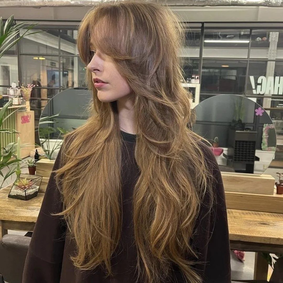 Woman showing long textured wolf haircut with curtain bangs in a salon