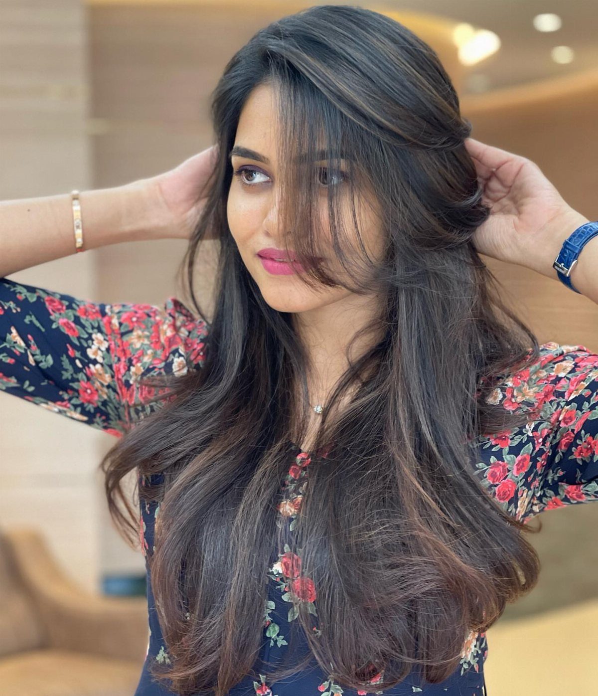 Woman showing long, voluminous side-swept layers over a floral top