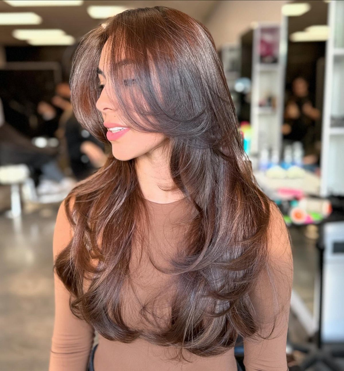 Long brown side-parted fringe layers styled in voluminous, rounded waves