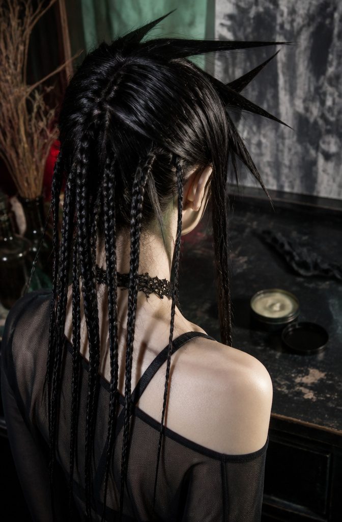 Spindly braids with uneven gelled spikes framing the face