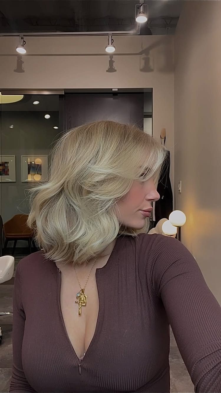Woman with voluminous blonde shoulder-length layers and side-swept fringe