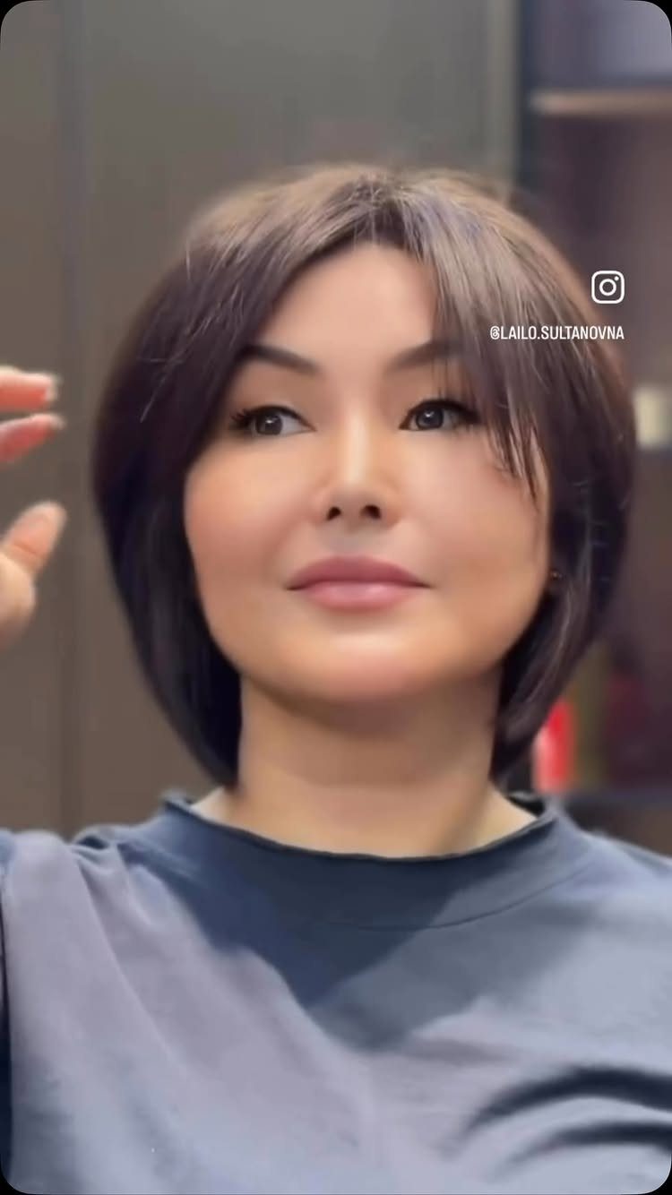 Woman showing a short layered brown bixie haircut with face-framing pieces
