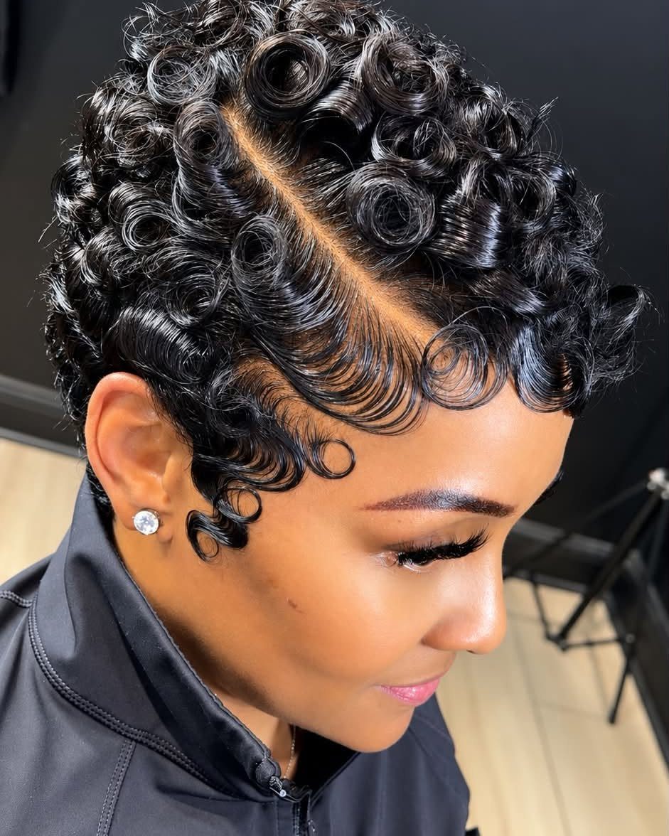 Woman displaying a short curly pixie cut with a deep side part
