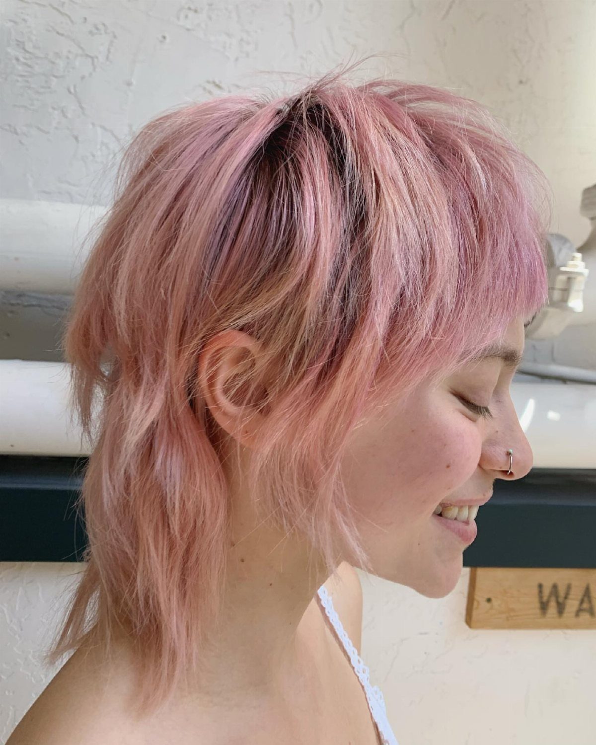 Pink layered pixie mullet with long bangs and a longer tapered back